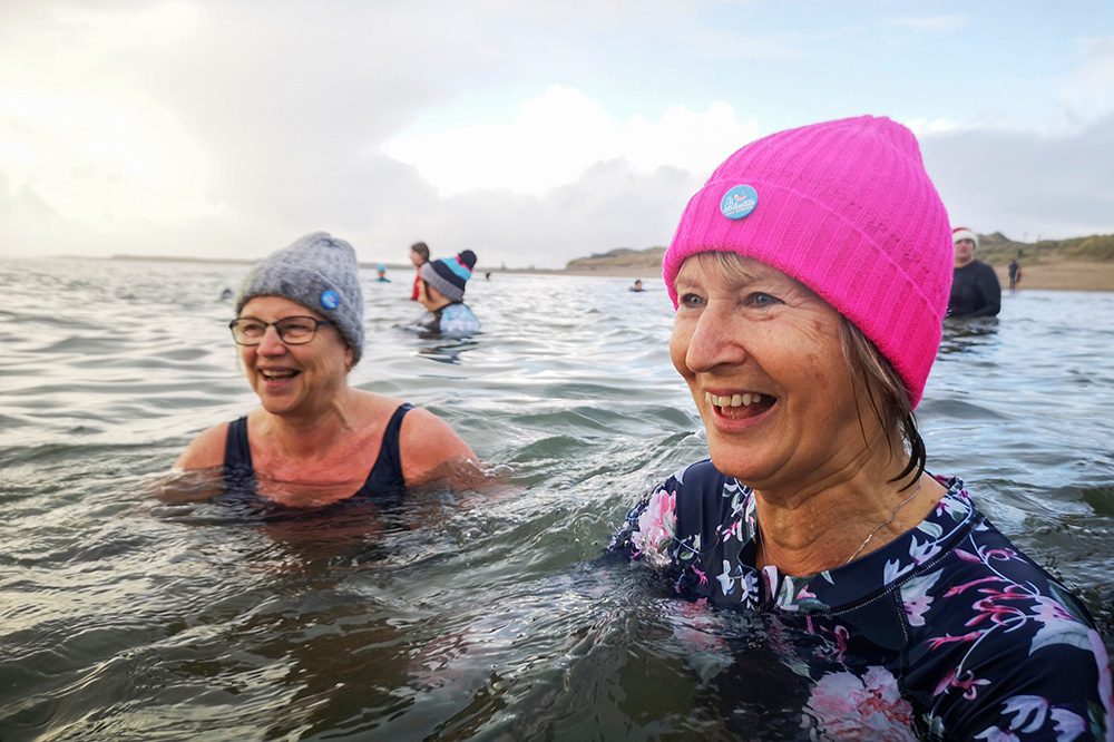 Two women swimming outdoors in cold water